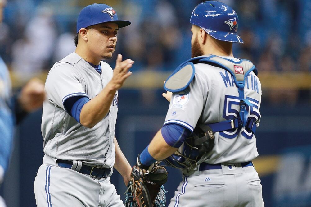 El pitcher Roberto Osuna y el catcher Russell Martin (55) celebraron el triunfo sobre los Rays, en el Tropicana Field (KIM KLEMENT. USA TODAY SPORTS)