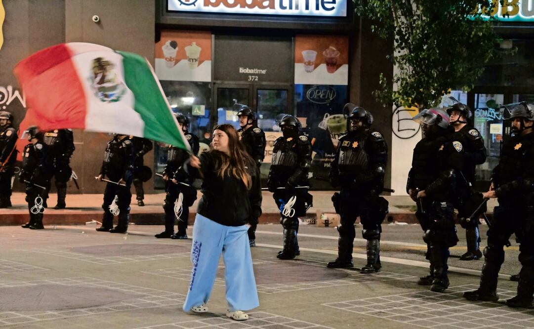 July ondea la Bandera Mexicana frente a agentes estadounidenses, en las protestas en Los Ángeles. “Estoy aquí por mi papi. Cuando era pequeña, lo deportaron”. Foto: Aimee Melo / EL UNIVERSAL