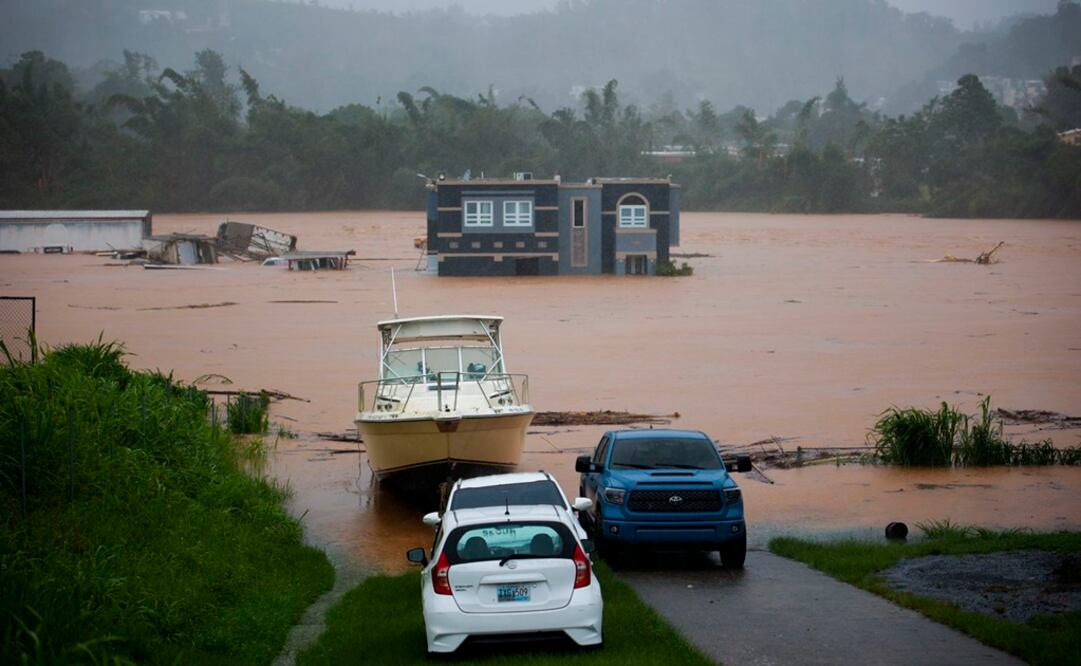 Personas dentro de una casa esperan ser rescatadas de las inundaciones causadas por el huracán Fiona en Cayey, Puerto Rico. Foto: AP 