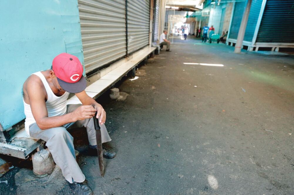 Un nicaragüense, al lado de un negocio que cerró en el Mercado Oriental, el mayor centro de compras del país, en Managua. Foto: INTI OCON. AFP