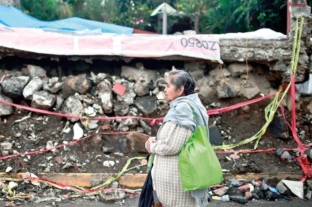 Habitantes de San Gregorio Atlapulco han tenido que reanudar actividades a pesar de que sus casas aún corren el riesgo de caer (RONALDO SCHEMIDT. AFP)