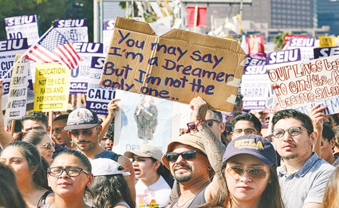 Supporters of the Deferred Action for Childhood Arrivals (DACA) chant slogans and hold signs while joining a Labor Day rally in downtown Los Angeles - Richard Vogel/AP