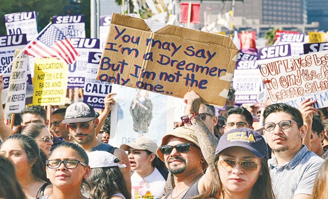 Supporters of the Deferred Action for Childhood Arrivals (DACA) chant slogans and hold signs while joining a Labor Day rally in downtown Los Angeles - Richard Vogel/AP