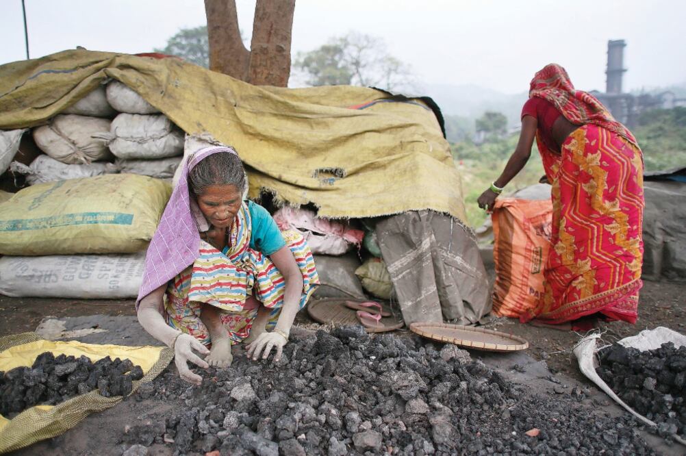 Mujeres en India recogen restos de carbón tirados por una fábrica en Gauhati, que usan después para cocinar (ANUPAM NATH. AP)
