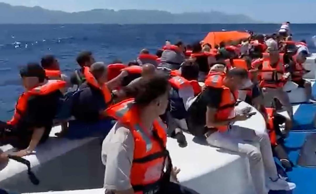 En esta imagen capturada de un video, pasajeros con chalecos salvavidas esperan sobre una embarcación de pasajeros volcada a ser rescatados frente a la costa de Girne, en la parte norte de Chipre ocupada por Turquía, el domingo 30 de agosto de 2026. Foto: AP