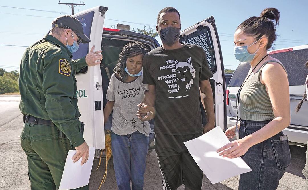 Un agente fronterizo de EU dejó a un par de migrantes con un grupo humanitario, en Del Río, Texas. Foto: Julio Cortez/ AP.