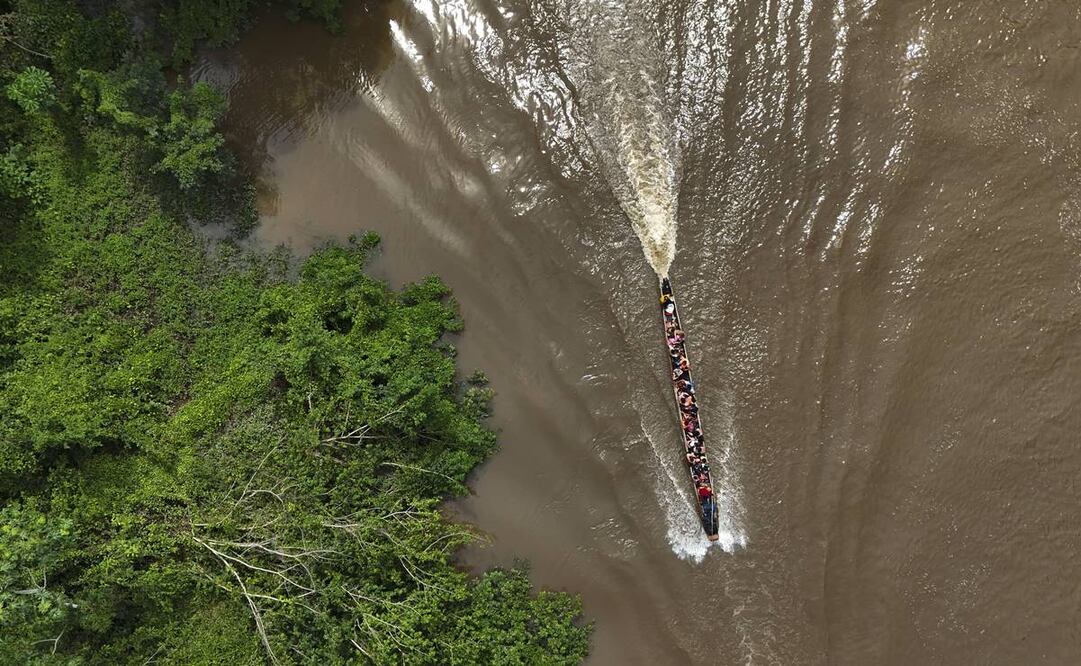 Migrantes viajan en una embarcación hacia Lajas Blancas, Panamá. Foto: AP