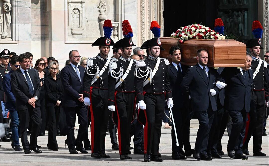 Los portadores del féretro seguidos por miembros de la familia llevan el ataúd del exprimer ministro italiano y magnate de los medios, Silvio Berlusconi, frente a la catedral del Duomo en Milán. Foto: AFP