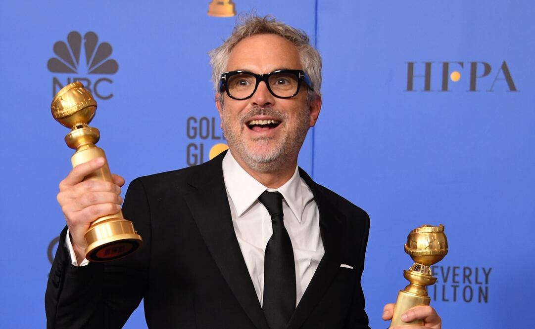 El cineasta mexicano Alfonso Cuarón sosteniendo los Globos de Oro que ganó por ROMA. Foto: AP, archivo 