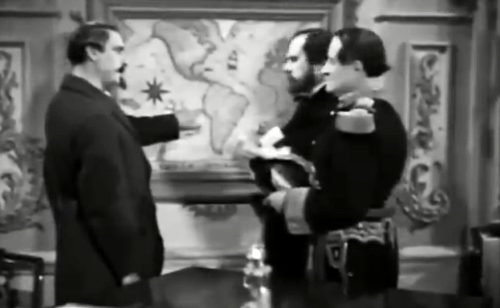 Escena donde el emperador Napoleón III (Ángel Sala) equivoca la ubicación de México en un mapa. La ignorancia y soberbia que se adjudicaron a los franceses generó descontento con la cinta. Foto: Captura de Pantalla/ESPECIAL.