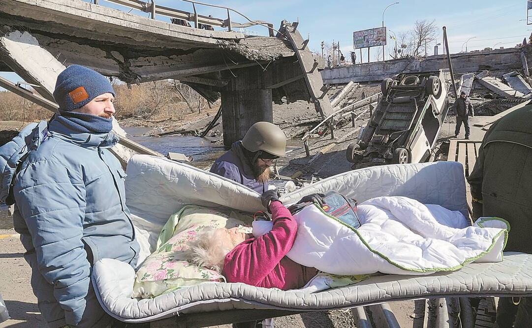 Voluntarios desalojan a una ucraniana mayor en Irpin, un suburbio de Kiev que lleva días bajo el impacto del bombardeo ruso. Foto: EFREM LUKATSKY/ AP.