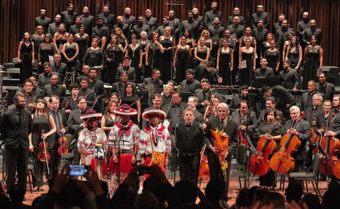 Philip Glass standing next to Huichol musicians and the National Symphonic Orchestra of Mexico - Photo: Taken from Philip Glass' Twitter profile
