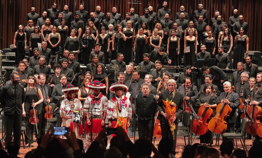 Philip Glass standing next to Huichol musicians and the National Symphonic Orchestra of Mexico - Photo: Taken from Philip Glass' Twitter profile