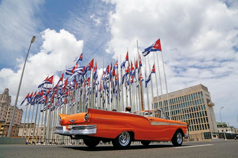 Un convertible clásico pasa junto a la embajada de Estados Unidos en La Habana, que será oficialmente reabierta el 14 de agosto (DESMOND BOYLAN. AP)