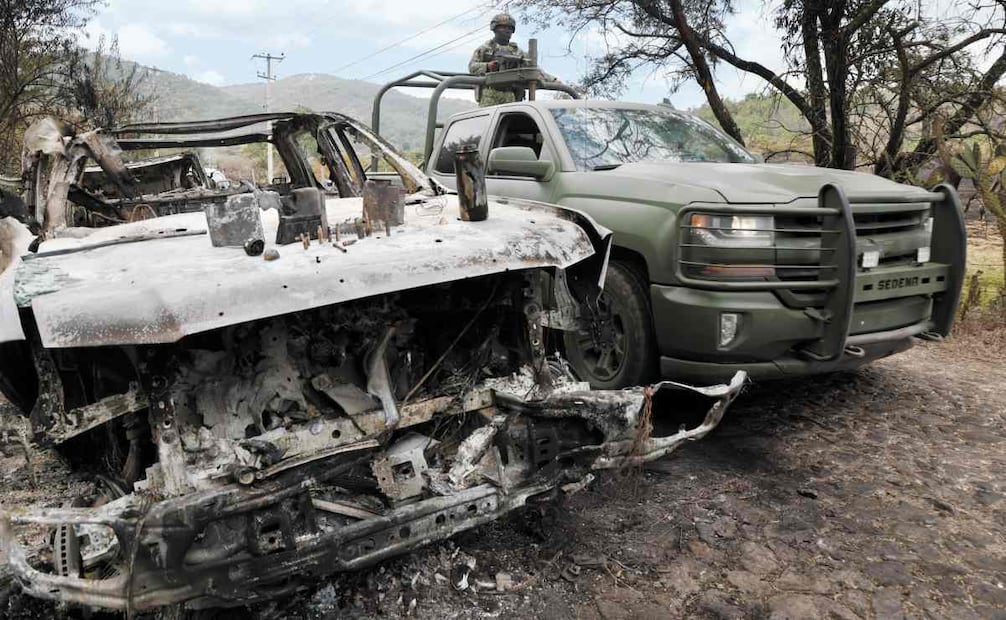 Un convoy de militares resguardaba la falda del cerro, en la que aún se notan las huellas del enfrentamiento, como el vehículo quemado de la imagen. Foto: Valente Rosas / EL UNIVERSAL