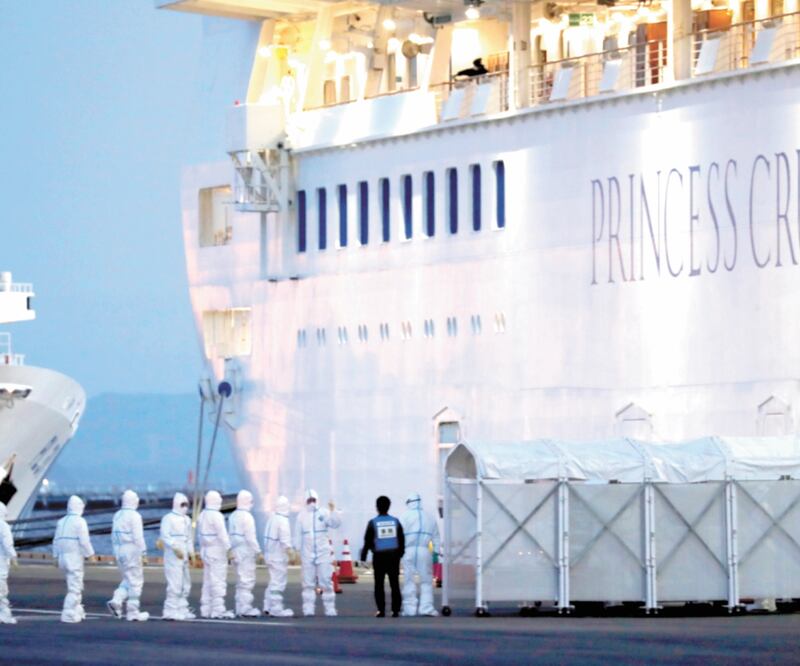Oficiales con equipo de protección ingresan al crucero Diamond Princess, en el que 64 personas han dado positivo por coronavirus, para transferir a un paciente al hospital después de que el barco llegó a la Terminal de Cruceros. Foto: REUTERS
