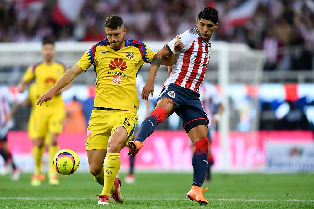 Guido Rodríguez y Alan Pulido durante el Clásico Nacional del Clausura 2018 de la Liga MX 