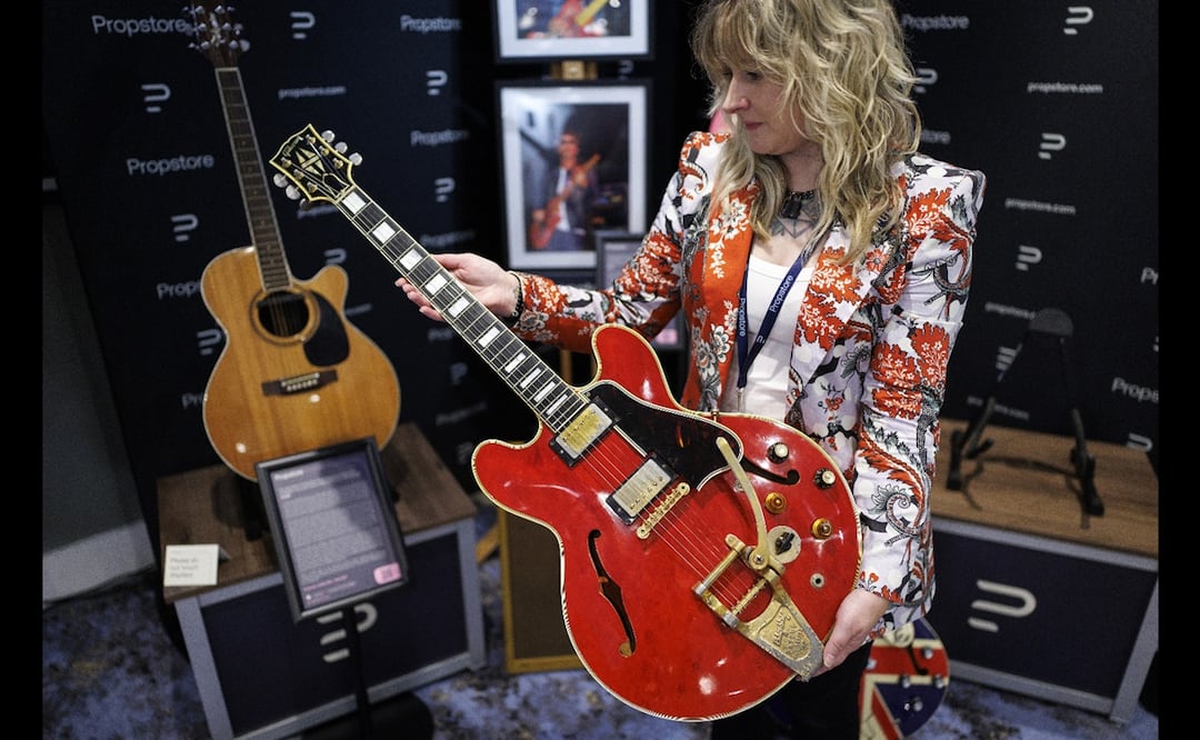 Un miembro del personal de la galería posa con la guitarra Gibson ES-355 Cherry Red de 1960 del cantante y compositor inglés Noel Gallagher, que fue dañada por Liam Gallagher en 2009 y provocó la separación de la banda de rock inglesa Oasis.
Foto: EFE/EPA/TOLGA AKMEN.