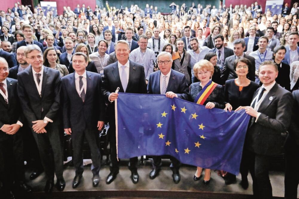 El presidente de la Comisión Europea, Jean-Claude Juncker (centro), sostiene la bandera de la Unión Europea, junto al presidente rumano, Klaus Iohannis (cuarto de izq. a der.), ayer en Sibu, Rumania. Foto: ROBERT GHEMENT. EFE