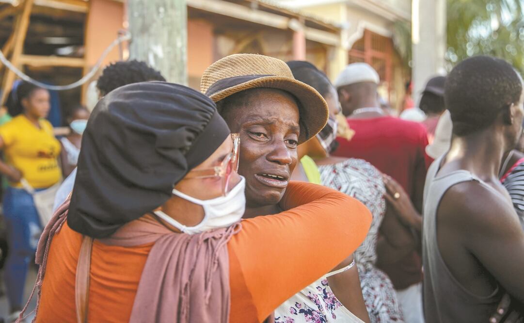 Haitianos comen en la calle, donde tuvieron que dormir tras el sismo de 7.2 grados del sábado. Foto: Joseph Odelyn/ AP.