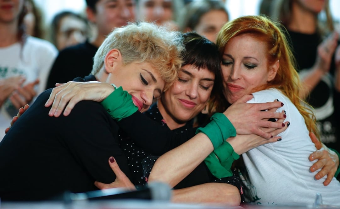 La maquilladora profesional Anahi De la Fuente (i) y las actrices Jazmin Stuart (c) y Anabel Cherubito se abrazan durante una rueda de prensa del colectivo de Actrices Argentinas. Foto: EFE/Juan Ignacio Roncoroni