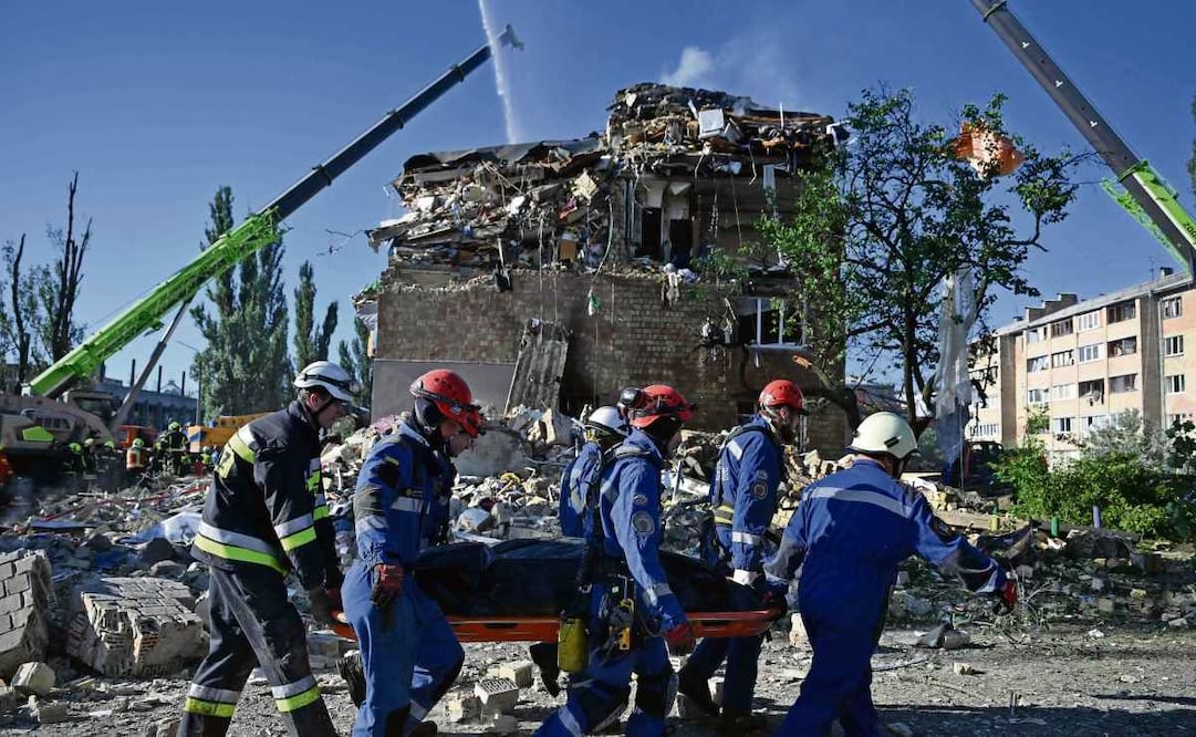 Rescatistas ucranianos transportan el cuerpo de una víctima mortal en un edificio residencial gravemente dañado tras un ataque con misiles rusos en Kiev. Foto: Genya Savilov / AFP