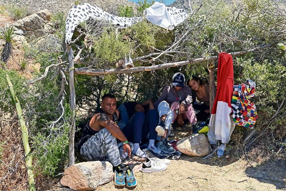 Migrantes colombianos, mientras esperan ser procesados ​​por los agentes de la Patrulla Fronteriza cerca de Jacumba Hot Springs, el sábado pasado.