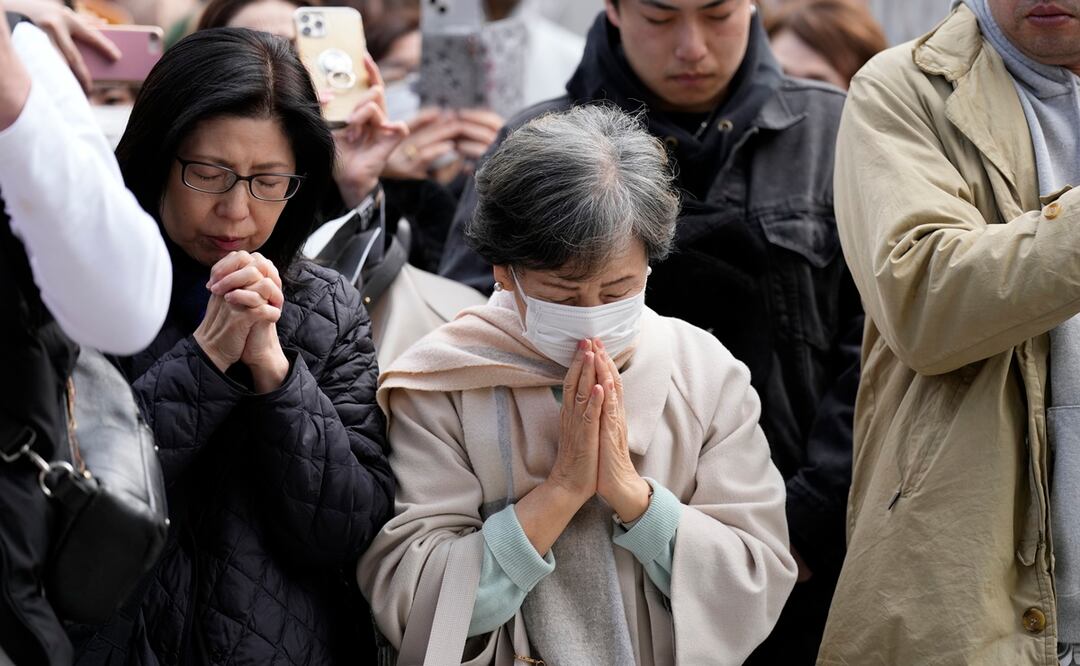 Personas orando en conmemoración de las víctimas del sismo y tsunami de hace 13 años en Japón, el 11 de marzo de 2024 en Tokio. Foto: AP