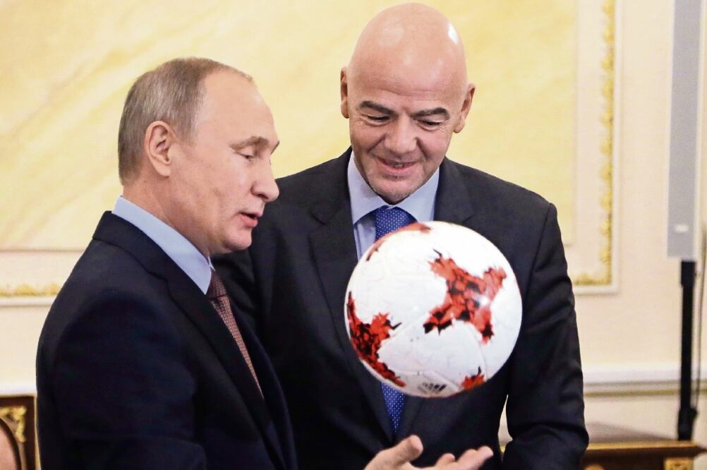 Vladimir Putin, izquierda, recibió un balón oficial para la Copa Confederaciones 2017, que le obsequió Gianni Infantino (MAXIM SHIPENKOV. AP)
