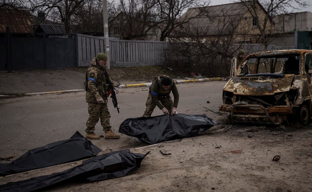 Soldados ucranianos recuperan los restos de cuatro civiles muertos del interior de un vehículo calcinado en Bucha, en las afueras de Kiev, Ucrania. Foto: AP