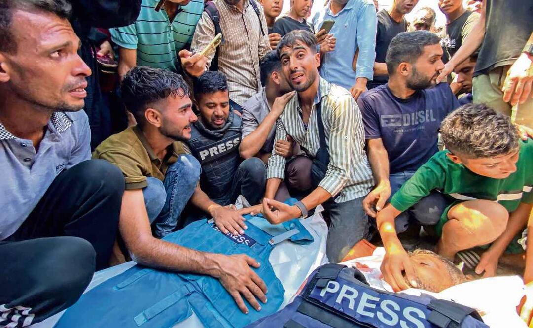 Personas lloran la muerte de los periodistas palestinos Moaz Abu Taha (izq.) y Hussam al-Masri, de Reuters (der.), en un ataque israelí contra el Hospital Nasser. Foto: AFP