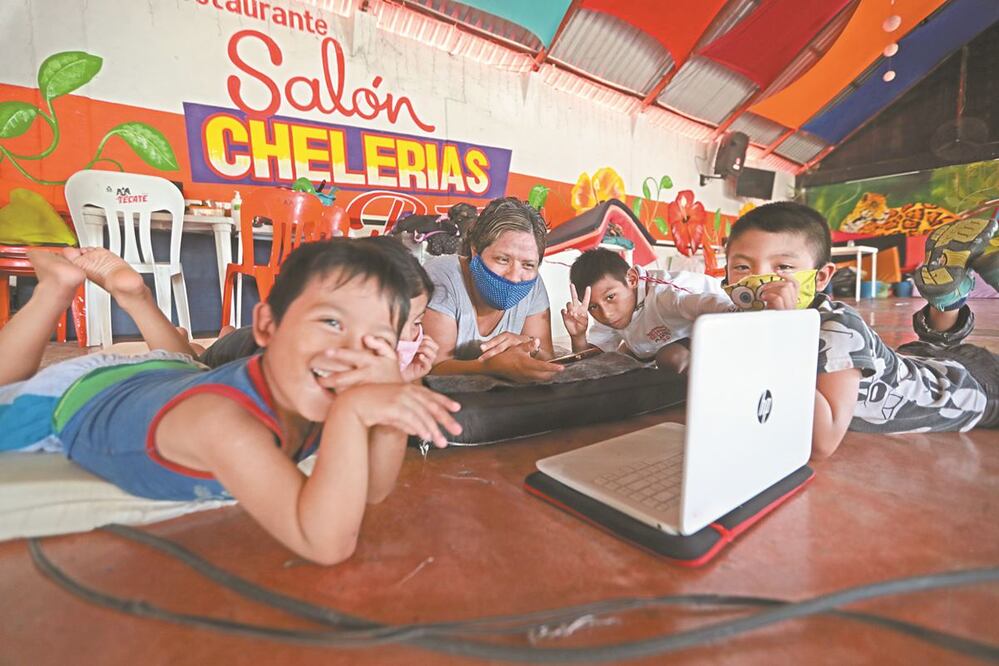 Amelia y sus hijos llevan una semana en el bar porque su hogar se inundó. Ella sólo pudo rescatar la computadora. GERMÁN ESPINOSA. EL UNIVERSAL