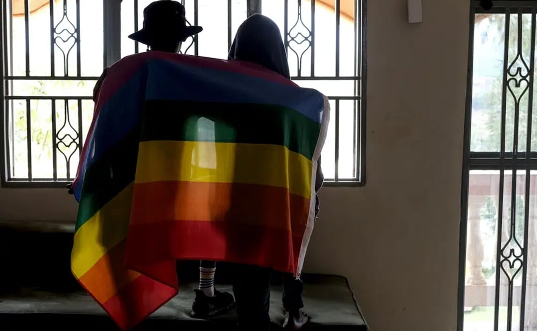 Una pareja gay de Uganda se cubre con una bandera del orgullo gay mientras posan para una fotografía en Uganda. Foto: AP