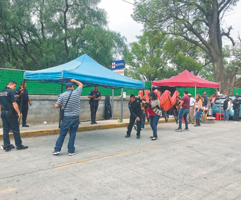 A las afueras del Hospital Regional de Alta Especialidad de Ixtapaluca colocaron carpas para familiares y amigos de los dos funcionarios lesionados. ESPECIAL