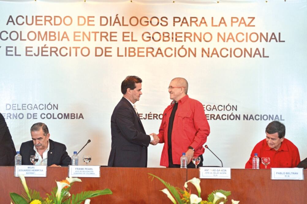 Frank Pearl, jefe de la delegación del gobierno colombiano, y Antonio García, jefe de la delegación del Ejército de Liberación Nacional (ELN), estrechan sus manos durante el acuerdo para la paz, en Caracas, Venezuela (OMAR NIETO REMOLINA. XINHUA)