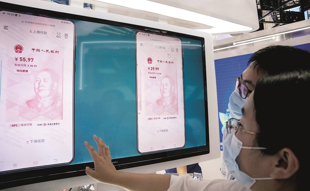 Visitantes de una feria comercial en Beijing miran el e-CNY, una versión digital del yuan chino. Foto: Archivo/ AP.