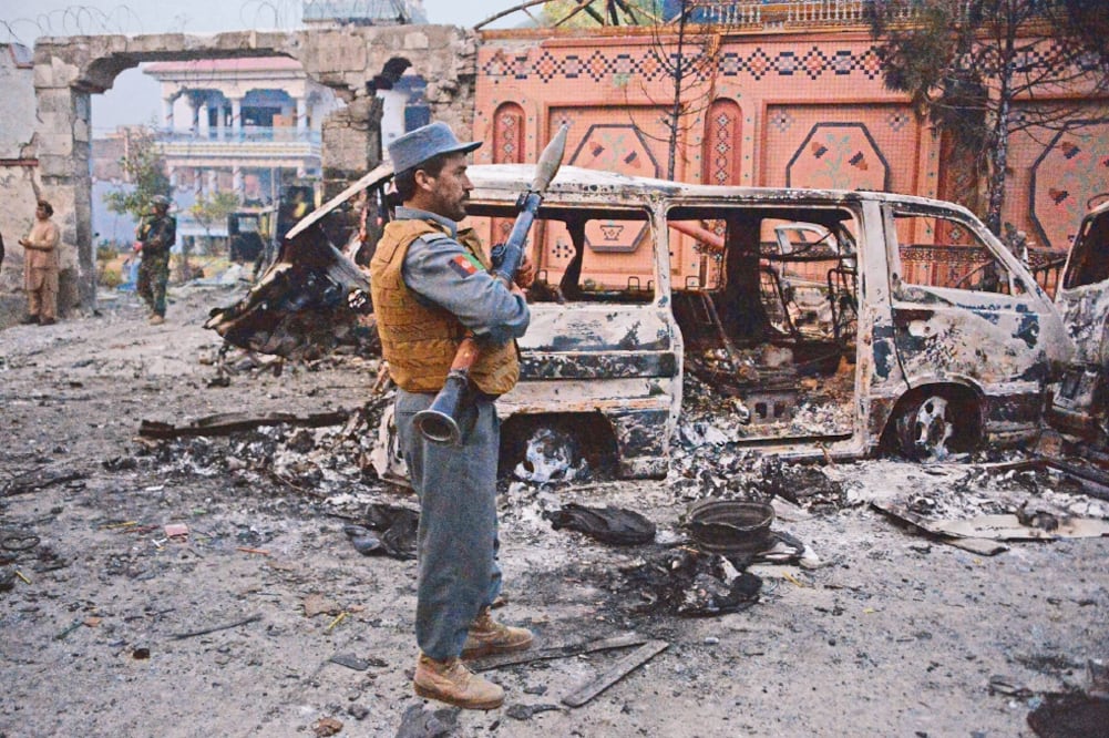 Destrucc ión. Oficiales afganos inspeccionan los daños en la entrada a la sede de la ONG luego del asalto que duró casi 10 horas (NOORULLAH SHIRZADA. AFP)