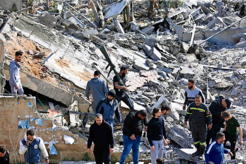 Personal de primeros auxilios y civiles, ayer en el lugar de un ataque aéreo israelí que impactó un edificio en la aldea de Sarafand, en el sur del Líbano. Foto: AFP