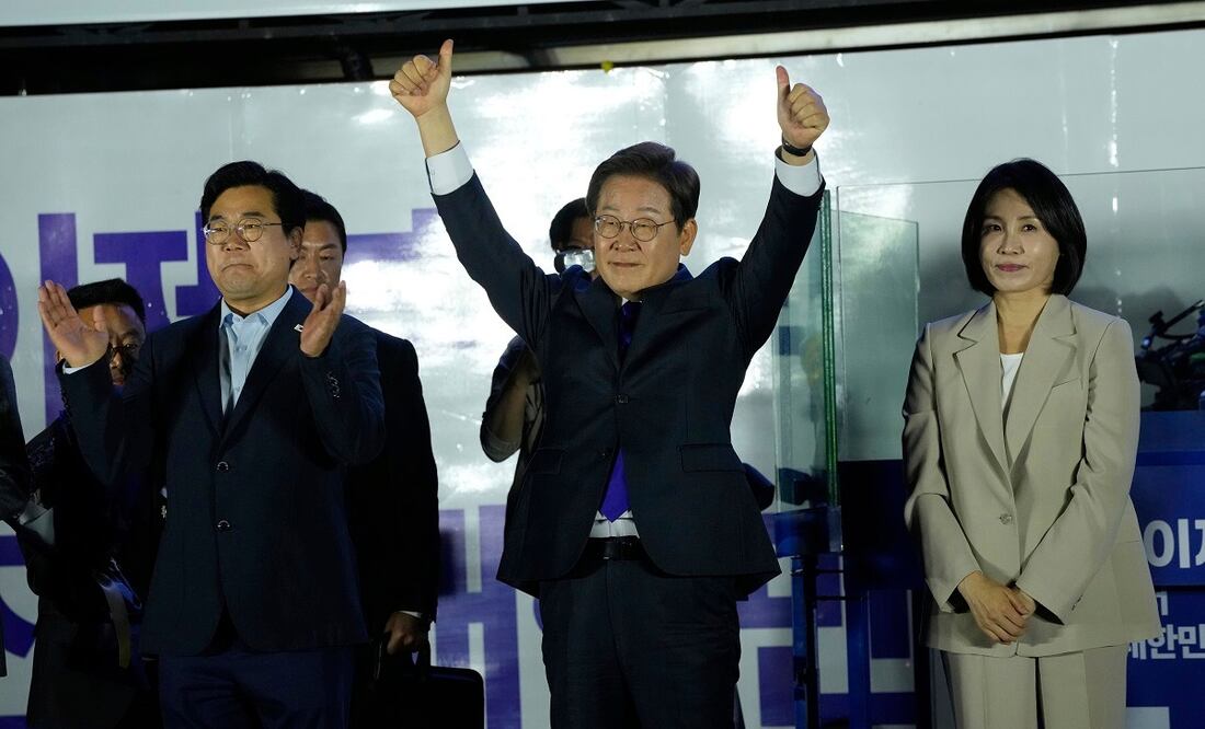 El candidato del Partido Democrático de Corea del Sur, Lee Jae-myung (centro), y su esposa Kim Hea Kyung, saludan a simpatizantes afuera de la Asamblea Nacional, en Seúl. FOTO: AHN YOUNG-JOON. AP