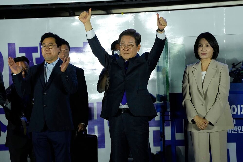 El candidato del Partido Democrático de Corea del Sur, Lee Jae-myung (centro), y su esposa Kim Hea Kyung, saludan a simpatizantes afuera de la Asamblea Nacional, en Seúl. FOTO: AHN YOUNG-JOON. AP