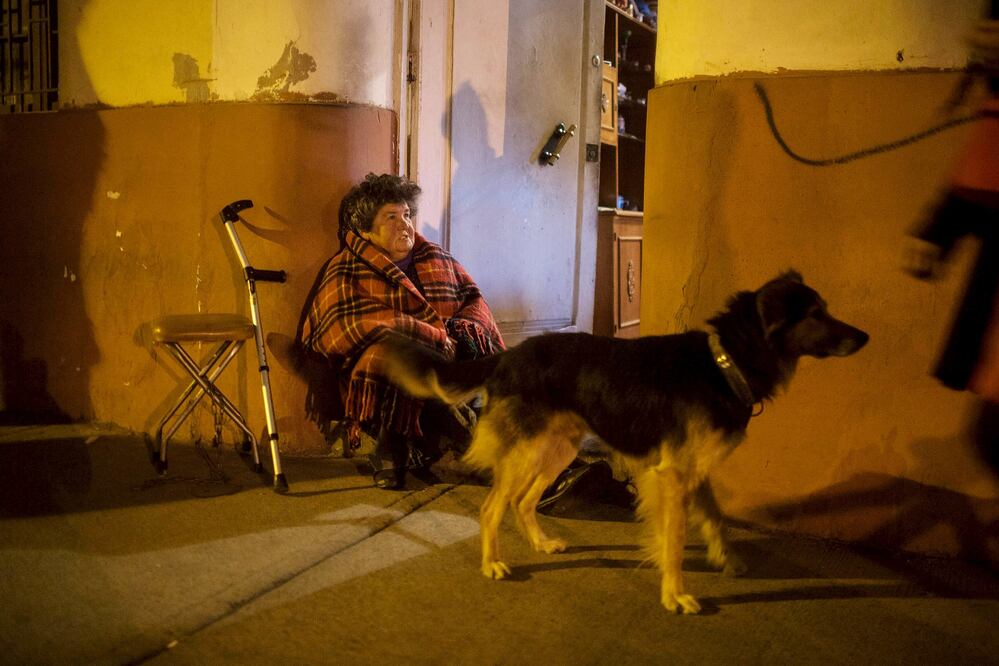 Una mujer espera fuera de su casa en Chile, el terremoto también se sintió en Perú (Reuters)