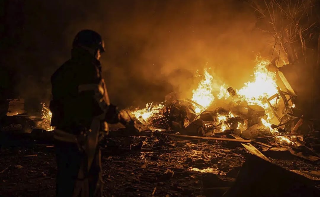 Bomberos apagan un incendio provocado por restos de un cohete ruso que había sido derribado por defensas antiaéreas, durante un ataque ruso en Kiev. Foto: AP