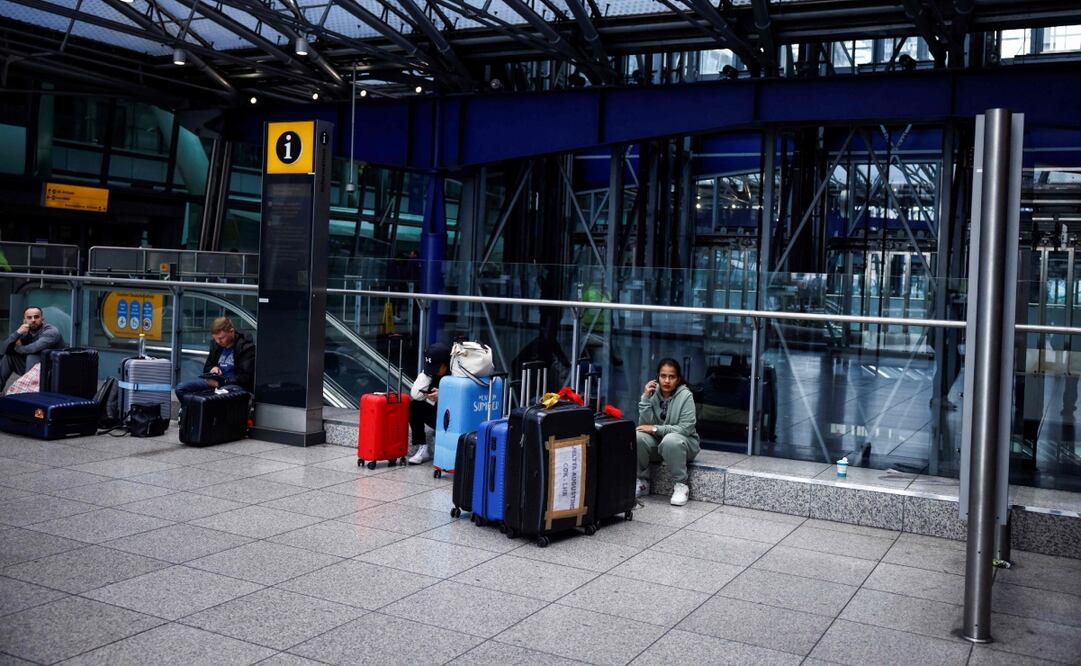 Los pasajeros con sus maletas esperan noticias en el aeropuerto de Heathrow luego de su cierre después de que estallara un incendio en una subestación que suministra energía al aeropuerto. Foto: AFP