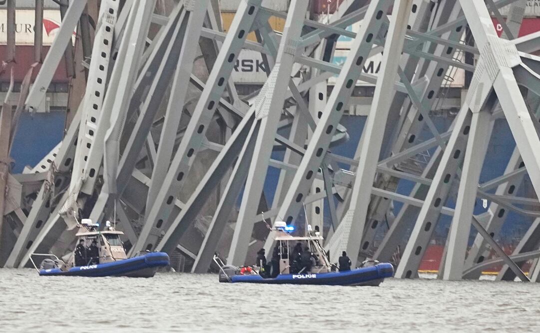Barcos de la policía trabajan alrededor de un carguero atrapado bajo parte de la estructura del puente Francis Scott Key, en Baltimore, un día después de que chocó contra una columna del puente y causó su derrumbe. Foto: AP