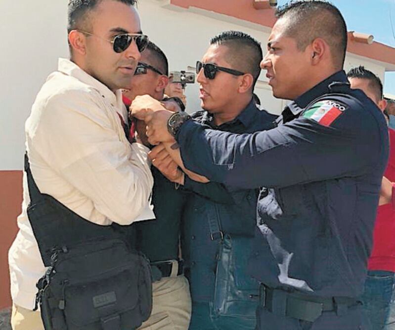 Un policía en Morelos desenfundó su arma de cargo para amagar a un grupo de manifestantes durante un evento del Presidente. ARCHIVO EL UNIVERSAL