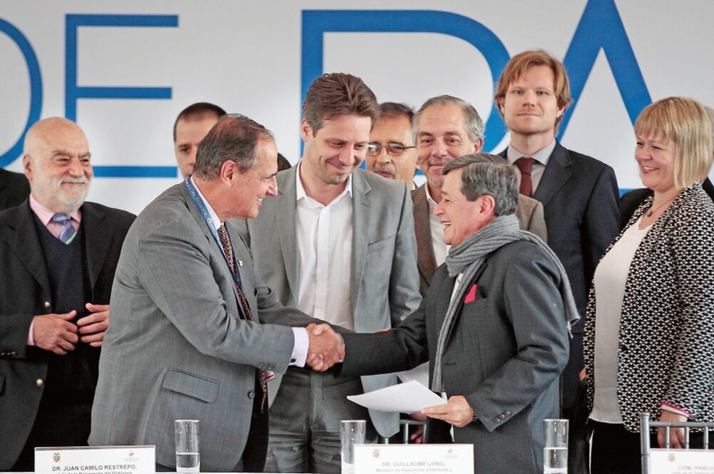 Los negociadores del gobierno de Colombia, Juan Camilo Restrepo (izq.), y del ELN, Pablo Beltrán (der.), se estrechan la mano tras la reunión, en Quito (JOSÉ JÁCOME. EFE)