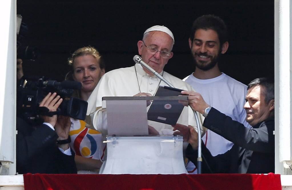 El pontífice invitó a dos jóvenes a acompañarle en la ventana del Palacio Apostólico y así abrir las inscripciones para participar en la Jornada Mundial de la Juventud en Cracovia (Polonia), a realizarse en 2016 (REUTERS)