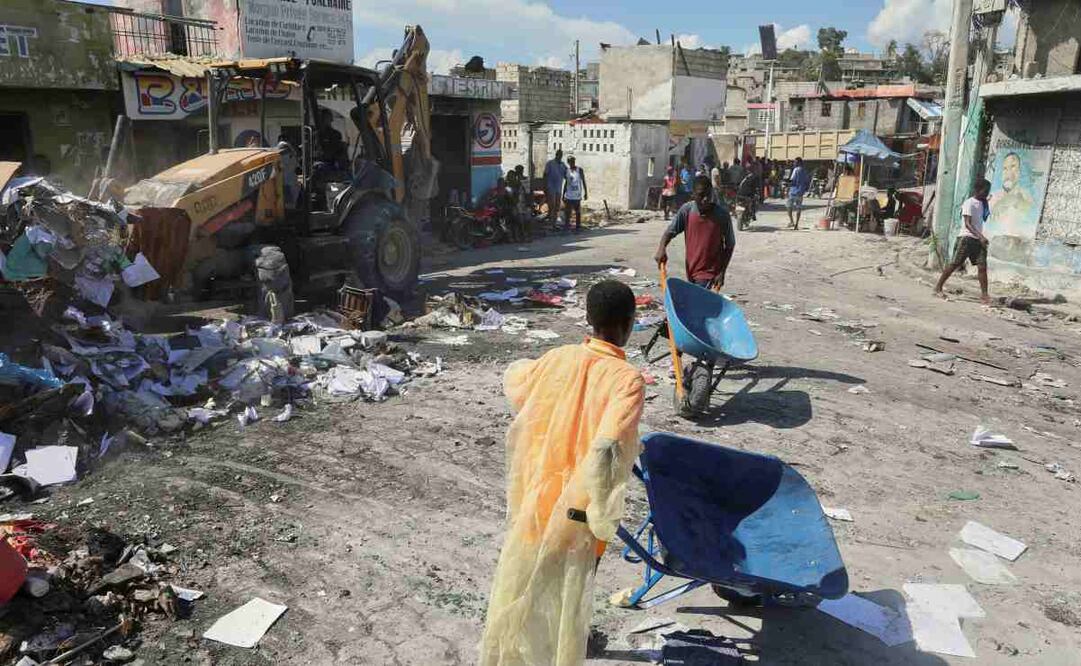 Jóvenes sacan escombros de sus casas dañadas por la violencia de pandillas en Puerto Príncipe. Foto: Odelyn Joseph / AP