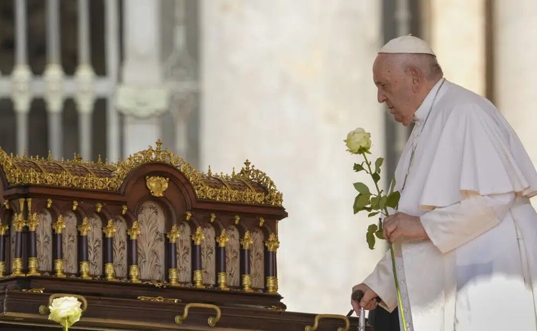 El papa Francisco, con una rosa en la mano, se dispone a rezar ante las reliquias de Santa Teresa del Niño Jesús, a su llegada a la audiencia nacional en la Plaza de San Pedro. Foto: AP