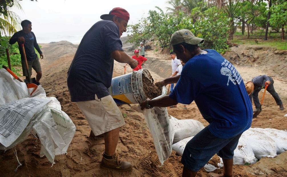 En la playa, habitantes rellenaron bultos con arena para colocar un muro que impida que las caídas de agua inunden los restaurantes. Foto: Edwin Hernández / EL UNIVERSAL